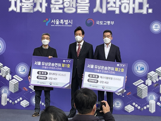 오세훈 서울시장이 29일 '자율차 유상운송 선포식'에서 상암의 자율차 유상운송을 최초로 시작하는 2개 업체(42dot·SWM)에 영업면허(자율차 유상운송 한정운수면허)를 수여한 뒤 포즈를 취하고 있다. <사진=박은희 기자>